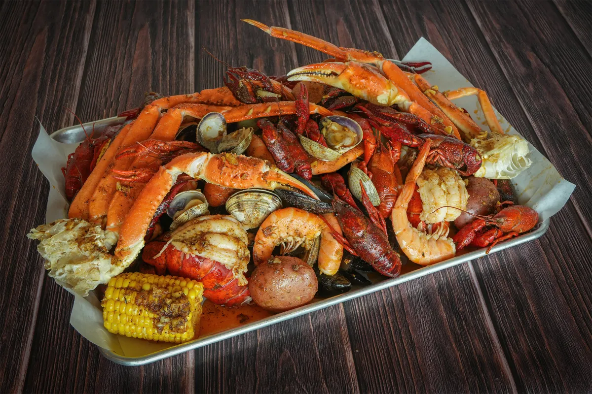 Seafood boil tray with crab legs, crawfish, shrimp and corn